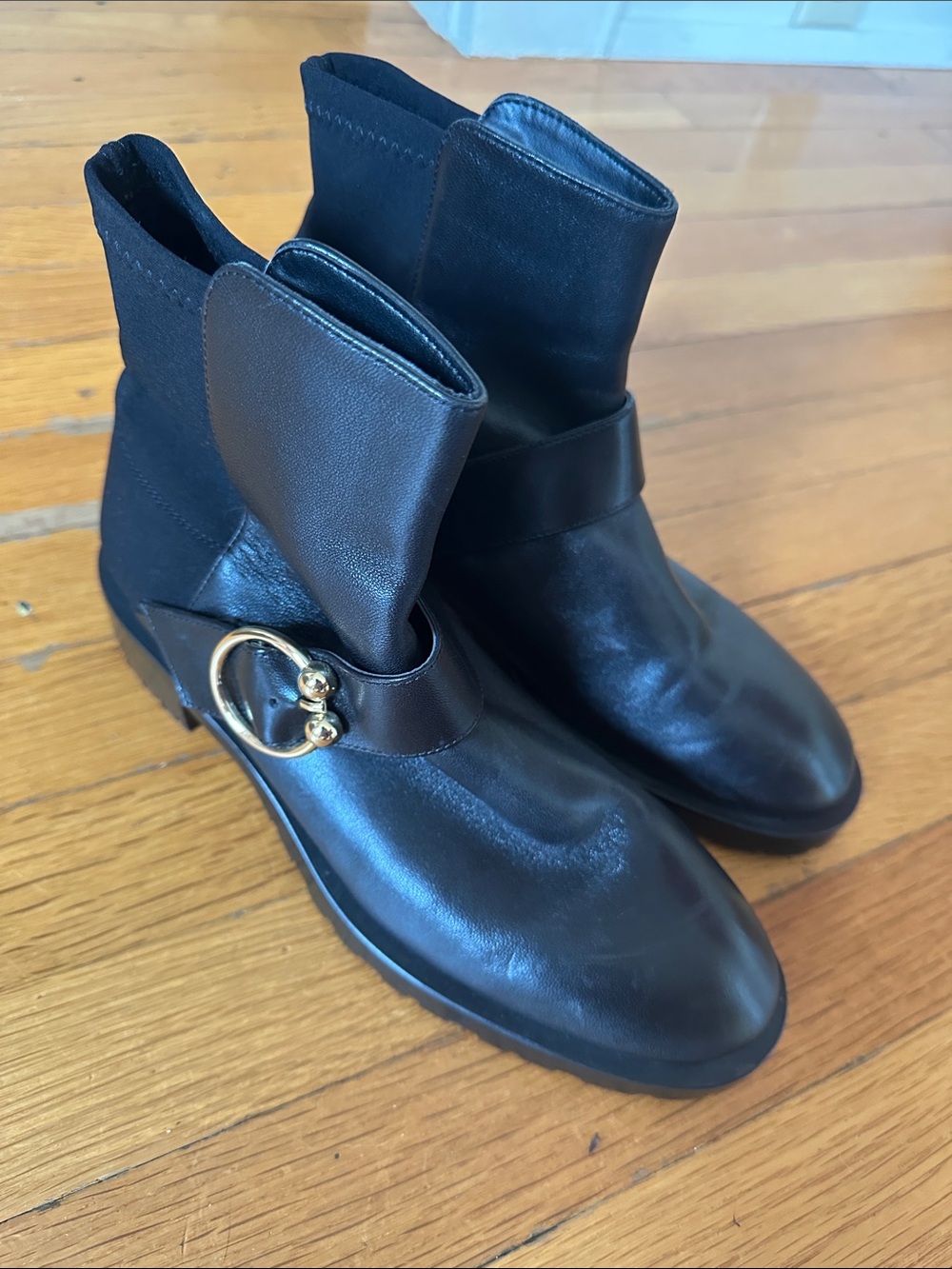 Stuart Weitzman Women’s Black Leather Ankle Boots with Gold Ring Accent